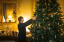 Visitor Services Manager Alice Matthews helps decorate a tree with Georgian period decorations.