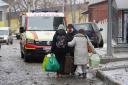 An injured man evacuates with family members from a residential building which was hit by a Russian rocket at the city centre of Kharkiv, Ukraine
