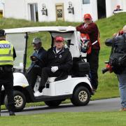 Ex President Donald Trump heads off on his golf buggy