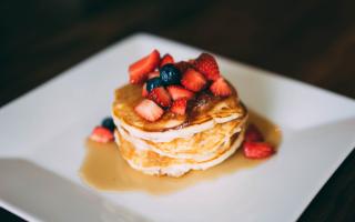 Pancakes topped with fruit and syrup. Credit: Canva